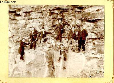 Une photographie originale ancienne en noir et blanc, d'un groupe de 7 hommes, perchs sur une facade rocheuse.